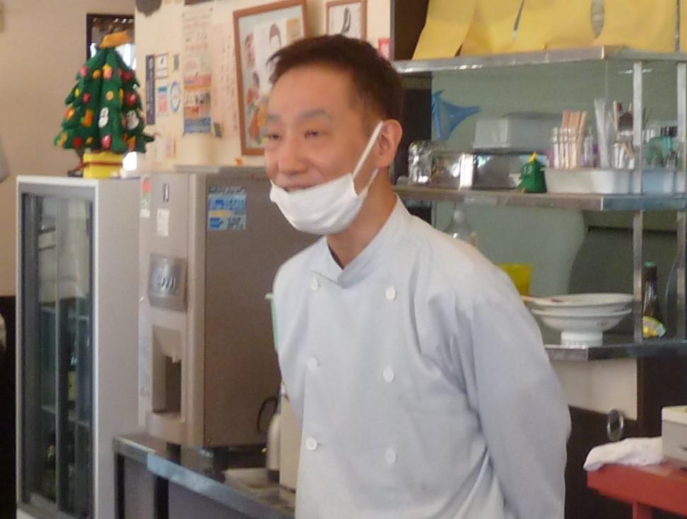キッチンに立っている男性 中程度の精度で自動的に生成された説明